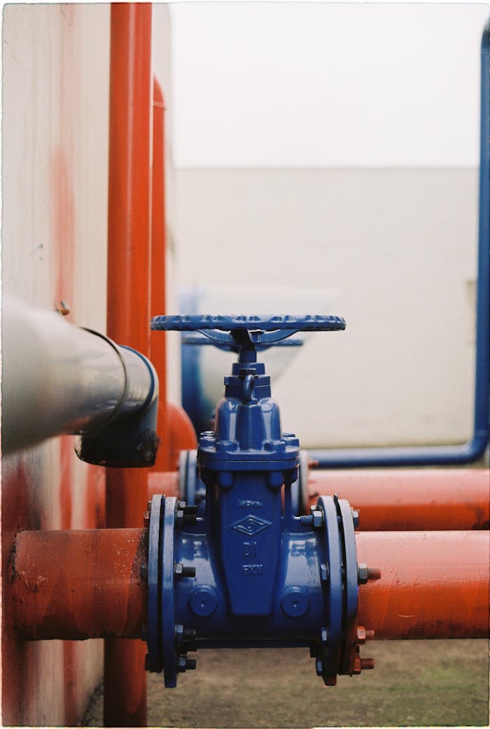 Crafting Captivating Headlines: Your awesome post title goes here Close-up of a blue gate valve on red pipes, showcasing industrial plumbing.